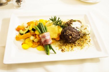 Biftek et ve et suyu sosu kızarmış sebze karışımı ve jambon rulo ile