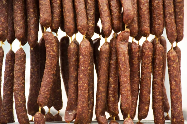 Salami en worst opknoping te koop bij biologische voeding straat marke — Stockfoto