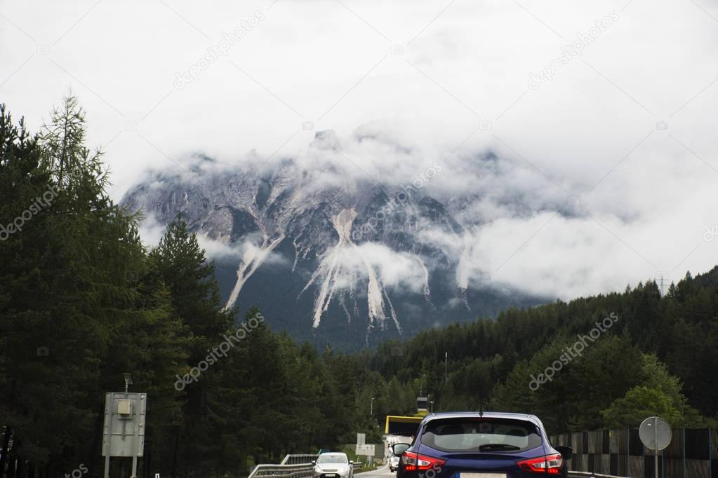 Travelers people driving car on the highway road go to Pfunds village with view landscape of alps mountain with clouds on September 1, 2017 in Biberwier, Austria