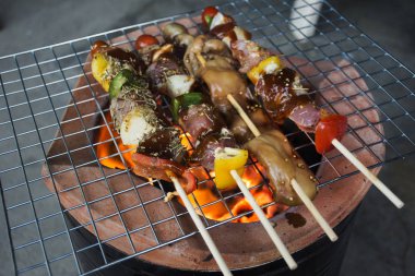 Tay pişirme et ve deniz ürünleri barbekü soba Tay tarzı üzerinde insanlar 