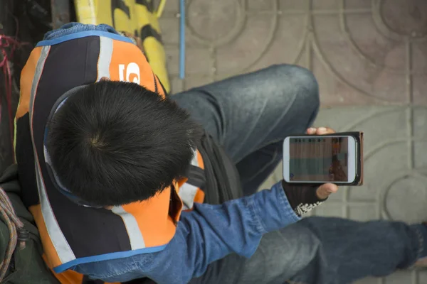 Мотоцикл такси тайцев людей, сидящих и играющих на смартфоне W — стоковое фото