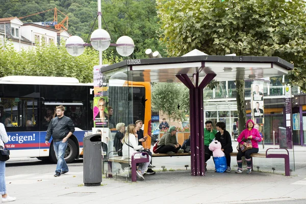 Viajeros alemanes y extranjeros personas caminando y esperando tranvía a — Foto de Stock