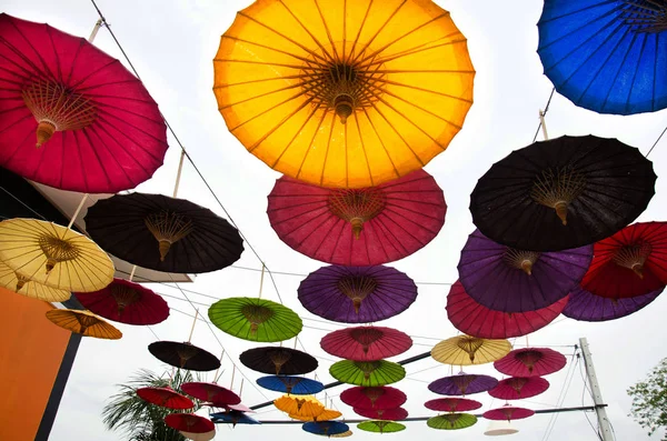 Decoração guarda-chuva colorido pendurado ao ar livre no jardim de flo — Fotografia de Stock