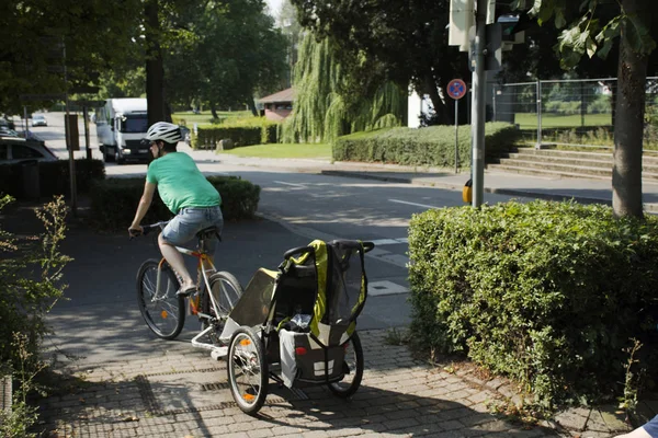 ドイツ人の母人自転車とベビーカーの子供たちの家に行く — ストック写真