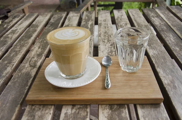 Latte art gorącej kawy na drewnianym stole w coffeeshop i Resta — Zdjęcie stockowe
