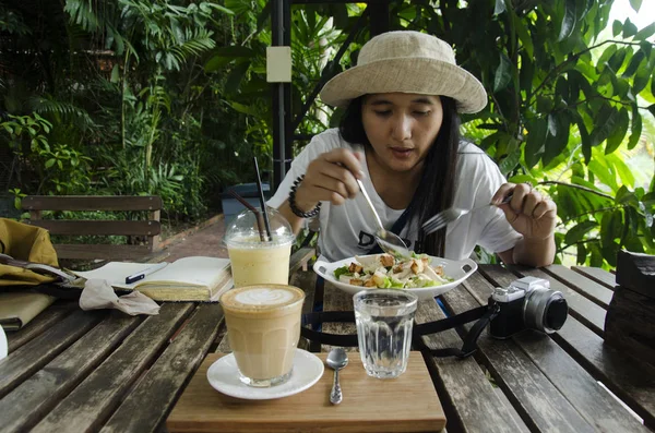 Travelers thai woman eating breakfast salad and coffee after wri — Stock Photo, Image