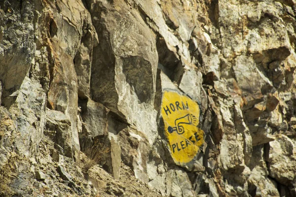 Предупреждающий знак безопасности на стене горы будьте осторожны рог, пожалуйста — стоковое фото