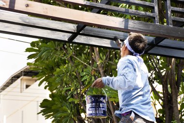 Bangkok, Tayland - 9 Kasım 2019 'da Tayland' da Bangkok, Tayland 'da inşaat alanının önündeki tente çatısını yapan ve elle boyayan insanlar
