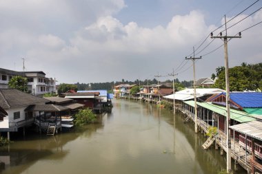 Amphawa nehrinin manzarasını, Amphawa şehrinin manzarasını ve Tayland Samut Songkhram şehrindeki Samutsongkhram şehrinde hafta içi yüzen pazarda yaşayan Taylandlı insanları izleyin.