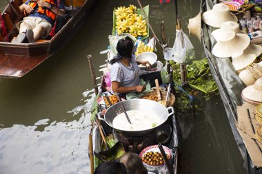 RATCHABURI, THAILAND - 30 Ekim 2019 'da Tayland halkı Tayland' ın Ratchaburi kentindeki Damnoen Saduak Yüzen Pazarı 'nda Tayland kanalı üzerinde Tayland tahtakurusu ve öncü gezginler için gıda ürünleri satıyor.