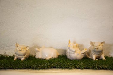 Bangkok, Tayland 'da tatil köyünde plastik çim dekorasyonuyla oynayan dört domuzcuk bebeği.