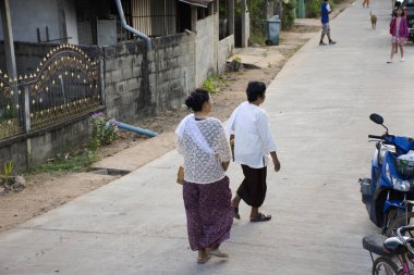 YASOTHON, THAILAND - 12 HAZİRAN: Taylandlı kadın yürüyüşü, 12 Ocak 2019 'da Yasothon, Tayland' da Budist bağış kasesine bağış toplamak ve evlilik kutlamalarına katılmak için gider.
