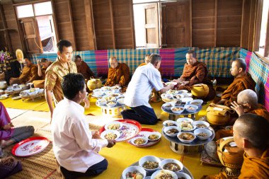 YASOTHON, THAILAND - 12 HAZİRAN: Tayland halkı 12 Ocak 2019 'da Yasothon, Tayland' daki Retro House 'da Budist sadaka kasesine yapışkan pirinç ve yiyeceklerle birlikte yiyecek sundu.