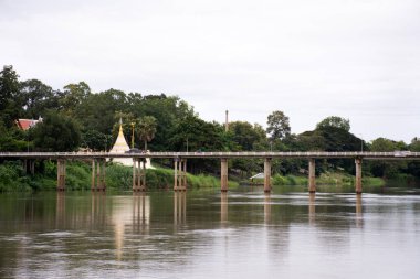 Wat Muang Tapınağı 'ndan pagoda chedi ve Tayland' ın Ratchaburi kentinde akşam vakti Ban Pong 'da Mae Khlong ya da Meklong nehrinden geçen yol köprüsü manzarası
