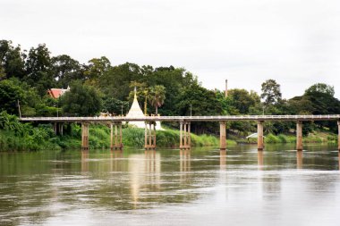 Wat Muang Tapınağı 'ndan pagoda chedi ve Tayland' ın Ratchaburi kentinde akşam vakti Ban Pong 'da Mae Khlong ya da Meklong nehrinden geçen yol köprüsü manzarası