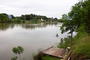 Wat Muang Tapınağı 'ndan pagoda chedi ve Tayland' ın Ratchaburi kentinde akşam vakti Ban Pong 'da Mae Khlong ya da Meklong nehrinden geçen yol köprüsü manzarası