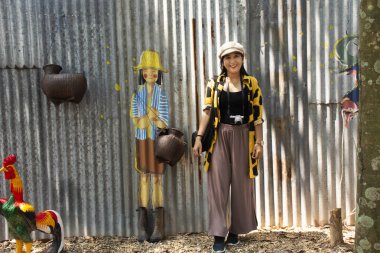 BUENG KAN, THAILAND - 3 Ekim 2019 tarihinde Bueng Kan, Tayland 'da bulunan So Phisai City' deki Yaşam Topluluğu Müzesi 'nde duvar yazısı ile duvar resmi ile poz veren Taylandlı kadınlar,