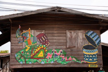 BUENG KAN, THAILAND - 3 Ekim 2019 'da Bueng Kan, Tayland' da bulunan So Phisai City 'deki Yaşam Topluluğu Müzesi' nde gezginler için duvarda grafiti resmi