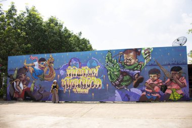 BUENG KAN, THAILAND - 3 Ekim 2019 tarihinde Bueng Kan, Tayland 'da bulunan So Phisai City' deki Yaşam Topluluğu Müzesi 'nde duvar yazısı ile duvar resmi ile poz veren Taylandlı kadınlar,