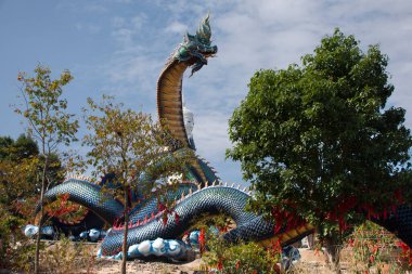 Tayland 'ın Mukdahan kentindeki Mukdahan Milli Parkı' na seyahat ve ibadet eden yabancılar için Wat Roi Phra Phutthabat Phu Manorom 'daki büyük mavi Naka ve beyaz Buda heykeli.