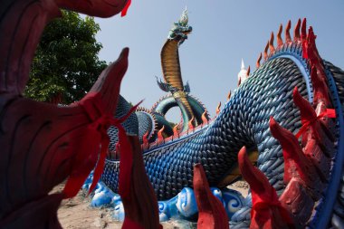 Tayland 'ın Mukdahan kentindeki Mukdahan Milli Parkı' na seyahat ve ibadet eden yabancılar için Wat Roi Phra Phutthabat Phu Manorom 'daki büyük mavi Naka ve beyaz Buda heykeli.