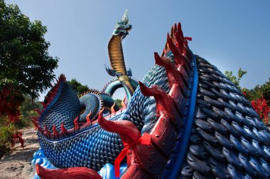 Tayland 'ın Mukdahan kentindeki Mukdahan Milli Parkı' na seyahat ve ibadet eden yabancılar için Wat Roi Phra Phutthabat Phu Manorom 'daki büyük mavi Naka ve beyaz Buda heykeli.