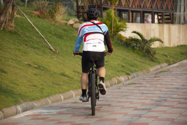 MUKDAHAN, THAILAND - 2 Ekim 2019 'da Mukdahan, Tayland' da nehir kenarındaki Mekhong nehrinde koşu yapan Taylandlı kadınlar ve Taylandlı erkekler ve bisikletli erkekler