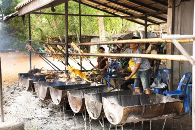 MUKDAHAN, THAILAND - 12 Ekim 2019 'da Tayland' ın Mukdahan kentinde, Kaengkabao restoranının mutfağında ızgara ve ızgara domuz eti pişiren insanlar