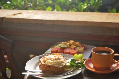 Amerikan Kahvaltısı ya da Kıtasal Kahvaltı Bali usulü sabah yemek odasında gezginler ve misafirler için Bali, Endonezya 'daki tatil otelinde yiyip içecekler.
