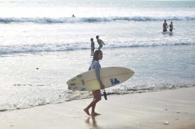 BALI, INDONEZYA - 25 Mart 2018 'de Endonezya' nın Bali kentinde Endonezya halkı ve yabancı gezginler yüzme ve deniz sörf tahtası oynayarak seyahat ediyorlar.