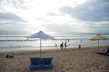 BALI, INDONEZYA - 25 Mart 2018 'de Endonezya' nın Bali kentinde Endonezya halkı ve yabancı gezginler yüzme ve deniz sörf tahtası oynayarak seyahat ediyorlar.