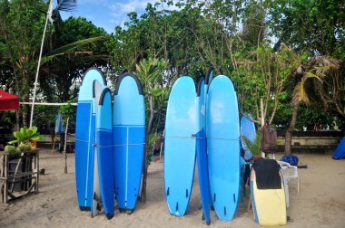 BALI, INDONEZYA - 25 Mart 2018 'de Endonezya' nın Bali kentinde, Endonezya halkı ve yabancı gezginler için sahilde sörf tahtası satan ve kiralayan balinalılar tatil için Kuta Plajı 'na gittiler.