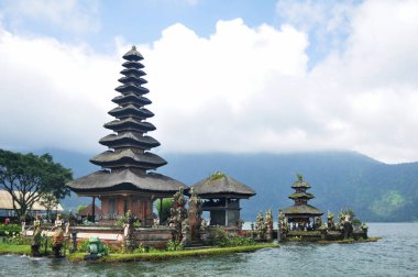 Gezginler için Pura Ulun Danu Bratan veya Pura Bratan Hindu Şii tapınağı arkeolojik sahasının Meru kuleleri Bali, Endonezya 'da Bedugul yakınlarındaki Bratan Gölü' nü ziyaret edip namaz kılarlar.