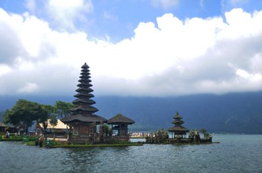 Gezginler için Pura Ulun Danu Bratan veya Pura Bratan Hindu Şii tapınağı arkeolojik sahasının Meru kuleleri Bali, Endonezya 'da Bedugul yakınlarındaki Bratan Gölü' nü ziyaret edip namaz kılarlar.