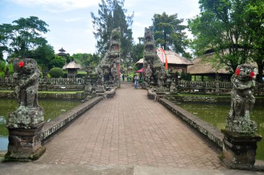 BALI, INDONEZYA - 24 Mart 2018 'de Endonezya' nın Bali kentinde, Badung şehrinde seyahat eden insanlar için antik yol köprüsü kanalı Pura Taman Ayun veya Mengwi Tapınağı girişine gidin