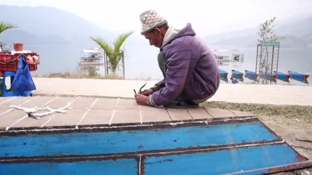 Pokhara Nepal 12月7日ネパール ポカラで2017年12月7日 ネパール ガンダキ プラデーシュ州の首都プエワ湖の河川敷で木造船の修理作業を行うネパール人大工 修理工高齢者 — ストック動画