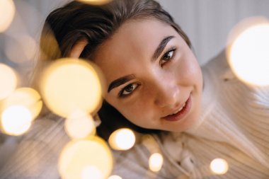 Yatakta iç çamaşırlarıyla poz veren seksi genç kadın..