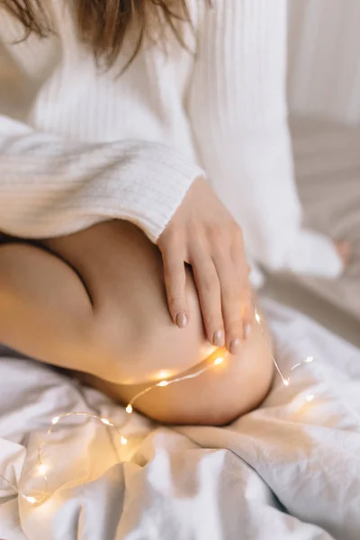 Jeune belle femme dans un pull chaud dans une chambre lumineuse dans un — Photo