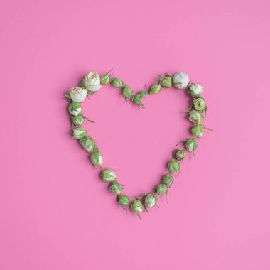 Pembe gül kalbiyle pembe arka plan üzerinde boş kopyalanmış alan. Düz