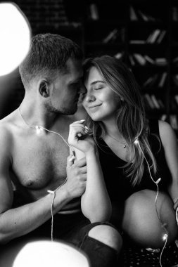 Mutlu adam gülümseyen hamile kadının karnına dokunuyor. 