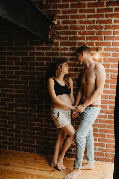 Feliz hombre tocando vientre de mujer embarazada sonriente — Foto de Stock