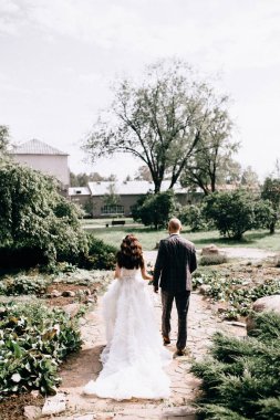 Güzel bir gelin, arkasında gelinliğiyle ayakta duruyor. Dantelli giyin. Mutlu gelin dönüyor.