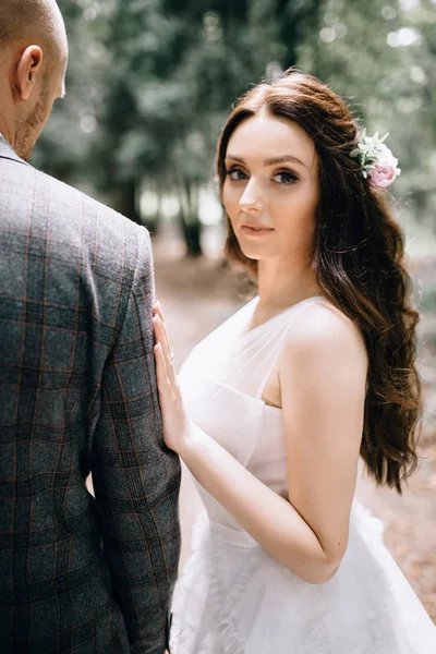 Schöne Braut in Mode Hochzeitskleid auf natürlichem Hintergrund. Die atemberaubende junge Braut ist unglaublich glücklich. Hochzeitstag. .Ein wunderschönes Brautporträt im Wald — Stockfoto