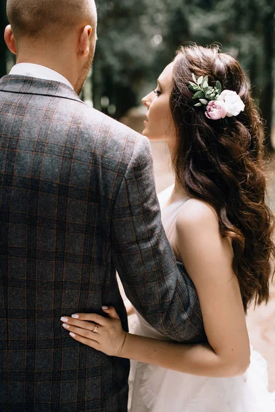 Visão traseira close-up dos penteados de casamento acabados na forma noiva com decoração de flores — Fotografia de Stock
