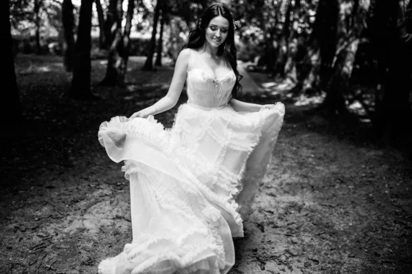 Belle mariée en robe de mariée de mode sur fond naturel.La superbe jeune mariée est incroyablement heureuse. Jour du mariage. .Un beau portrait de mariée dans la forêt — Photo