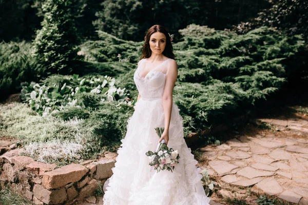 Όμορφη νύφη στο νυφικό μόδας σε φυσικό φόντο.Η εκπληκτική νεαρή νύφη είναι απίστευτα ευτυχισμένη. Την ημέρα του γάμου. Ένα όμορφο πορτραίτο νύφης στο δάσος — Φωτογραφία Αρχείου