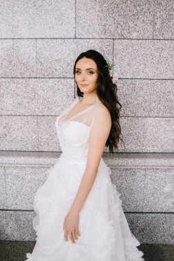 Binanın arka planında güzel beyaz ve uzun bir elbise içinde gelin.