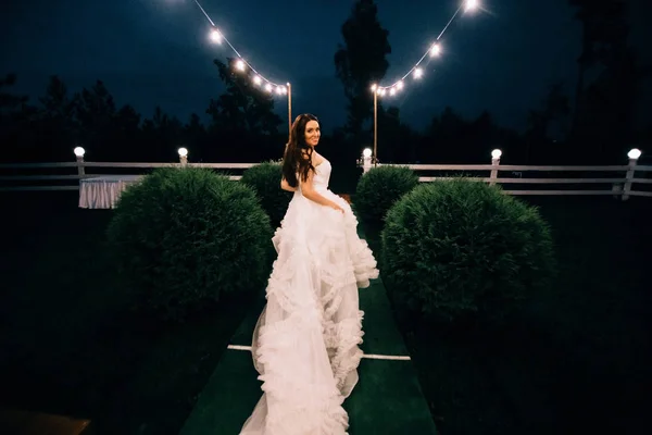 Πορτρέτο της νεαρής όμορφης νύφης σε λευκό νυφικό σε εξωτερικούς χώρους τρέχει μακριά το βράδυ — Φωτογραφία Αρχείου