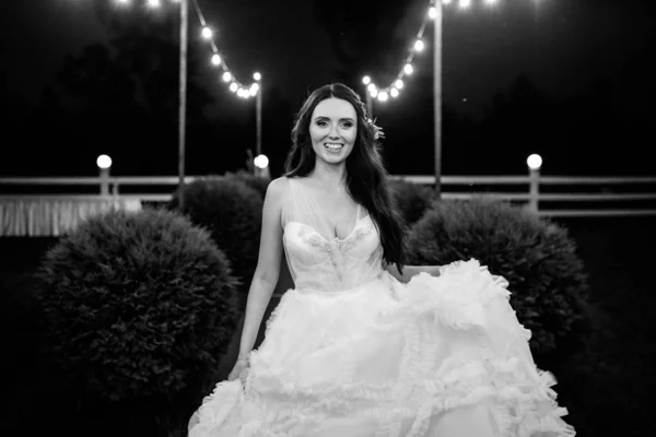 Porträt einer jungen hübschen Braut im weißen Hochzeitskleid, die nachts davonläuft — Stockfoto