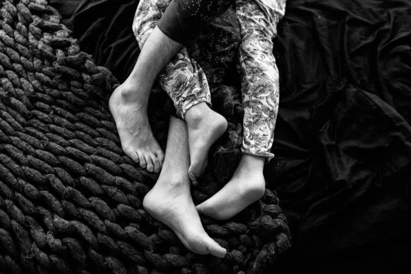 情熱的な愛。ベッドの上に寝そべっている若いカップルの足 — ストック写真